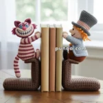 Two crocheted bookends on a wooden table, featuring a smiling pink-striped cat on the left and a character with a grey top hat on the right, holding a few books upright between them.