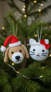 Knitted dog and cat ornaments hanging on a Christmas tree; the dog wears a red Santa hat, and the cat has a red bow.