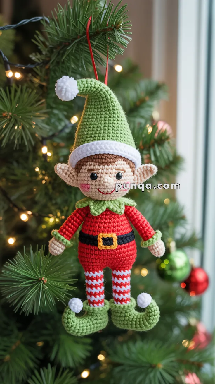Crocheted elf ornament in red and green, hanging on a Christmas tree with lights and baubles in the background.