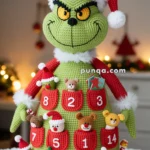 A crocheted Grinch figure wearing a Santa hat, designed as an advent calendar with numbered red pockets filled with small toys and trinkets.