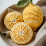 Crocheted lemon and lemon slices displayed on a beige cloth, with the website "punqa.com" visible.