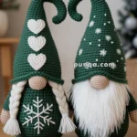 Two crochet gnomes with green hats; one with white hearts and braids, the other with snowflakes and a long beard.