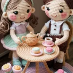 Two intricately crocheted dolls, one with a brown dress and the other in a pastel-colored dress, are sitting at a small circular table set with a tea pot, cups, and cookies in a cozy indoor setting. A crocheted rug and potted flowers add decorative details to the scene.
