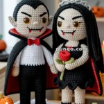 Two crocheted vampire dolls stand side by side on a table, surrounded by knitted pumpkins and lit candles, with a background of Halloween decorations.