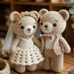 Two crocheted teddy bears dressed as a bride and groom, with the bride wearing a floral crown and the groom in a suit.