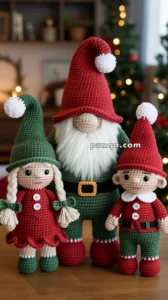 Three crocheted Christmas figures, including a gnome with a red hat and white beard, a doll with green hat and red dress, and an elf with a red outfit and green pants, are displayed on a wooden surface with a festive holiday background.