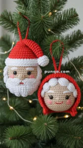 Crocheted Christmas ornaments depicting Santa Claus and Mrs. Claus hanging on a Christmas tree with pine branches and soft lights.
